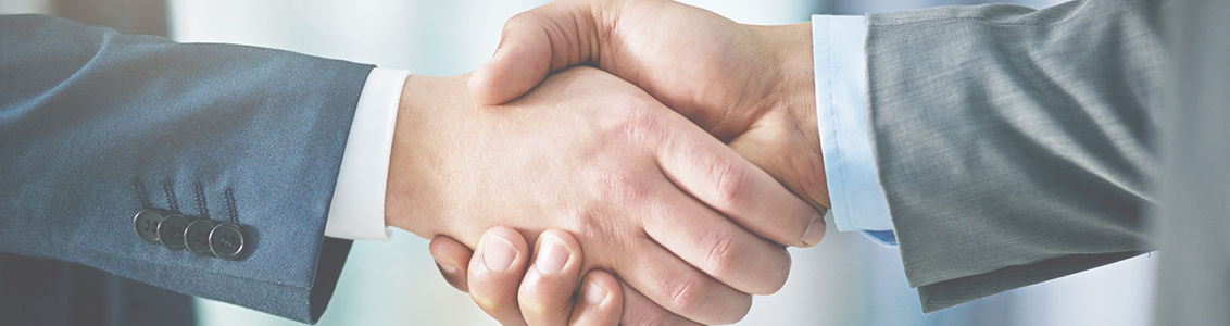 Closeup shot of two businessmen shaking hands in an office
